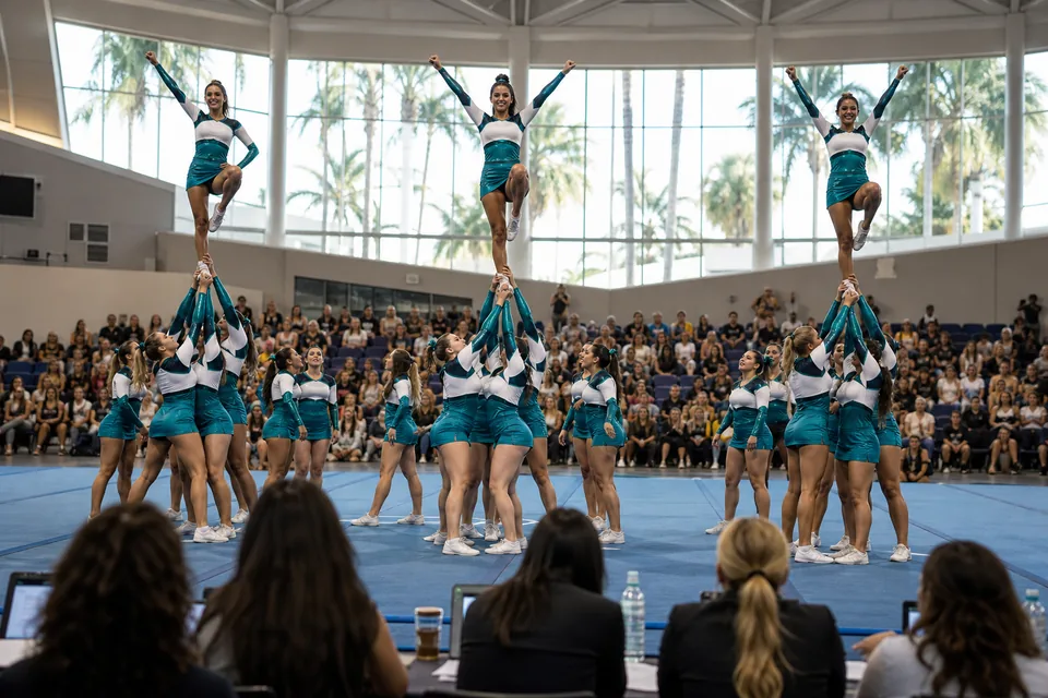 A high school competitive cheer team on a competition mat